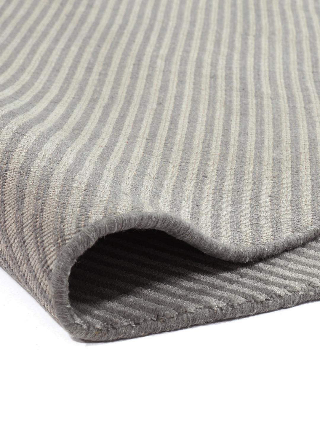 Un tapis rond gris avec un motif rayé subtil.