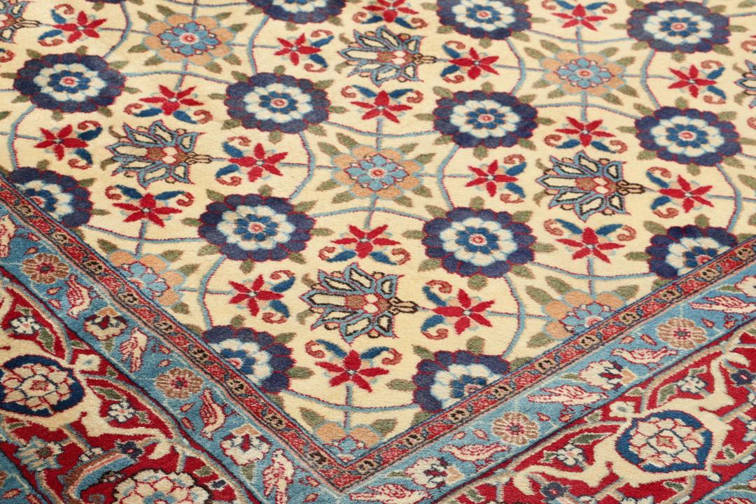 A rectangular Varamin rug from the Middle East with a beige field and red and blue floral patterns