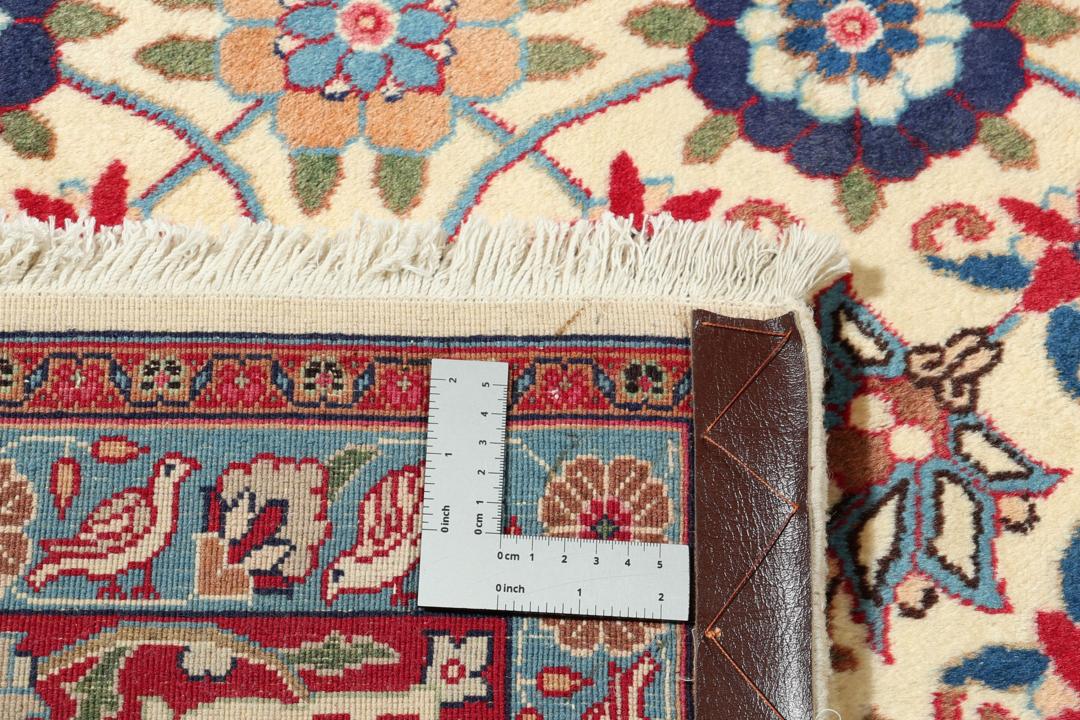 A rectangular Varamin rug from the Middle East with a beige field and red and blue floral patterns