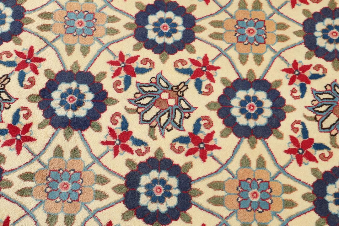 A rectangular Varamin rug from the Middle East with a beige field and red and blue floral patterns