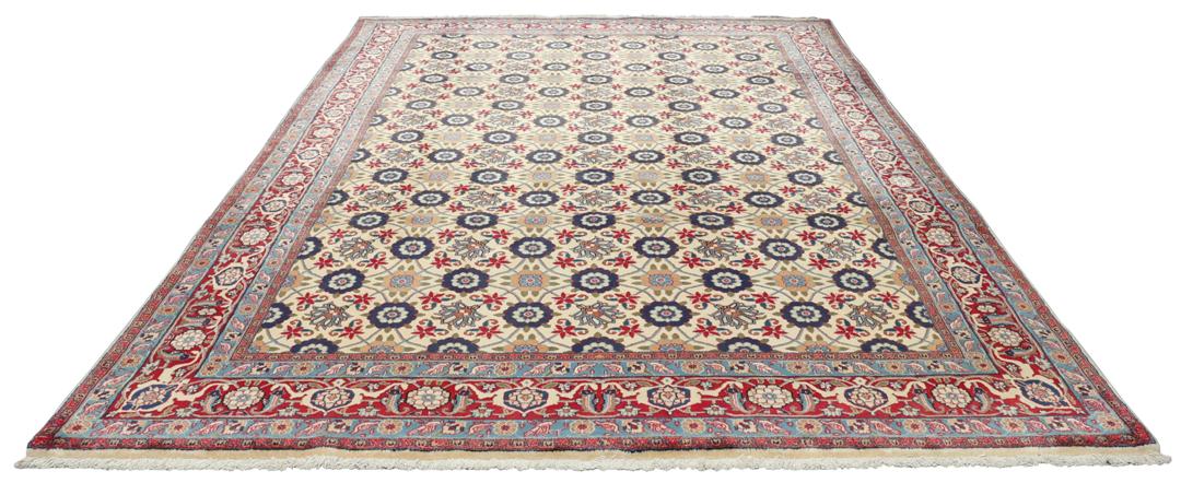 A rectangular Varamin rug from the Middle East with a beige field and red and blue floral patterns