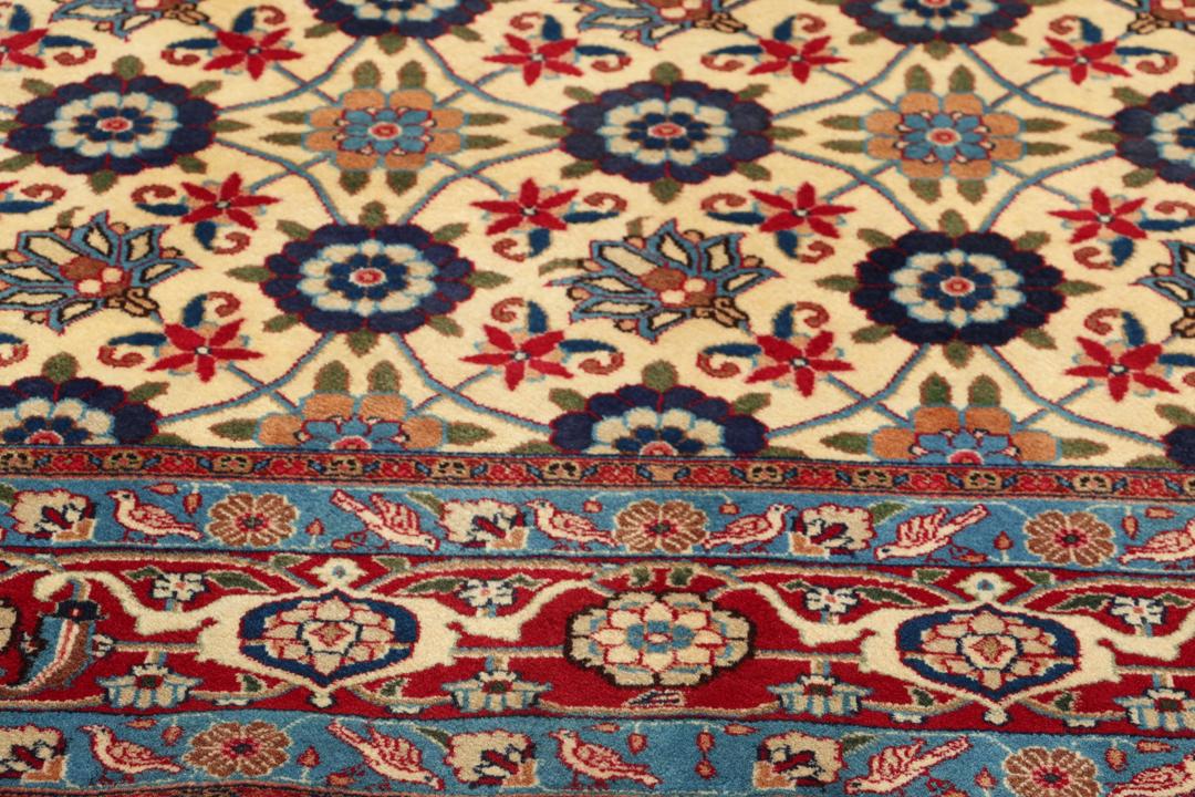 A rectangular Varamin rug from the Middle East with a beige field and red and blue floral patterns