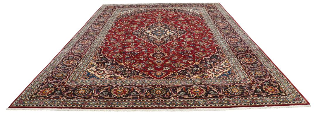 A beautiful red Keshan rug with a central medallion and intricate floral patterns.