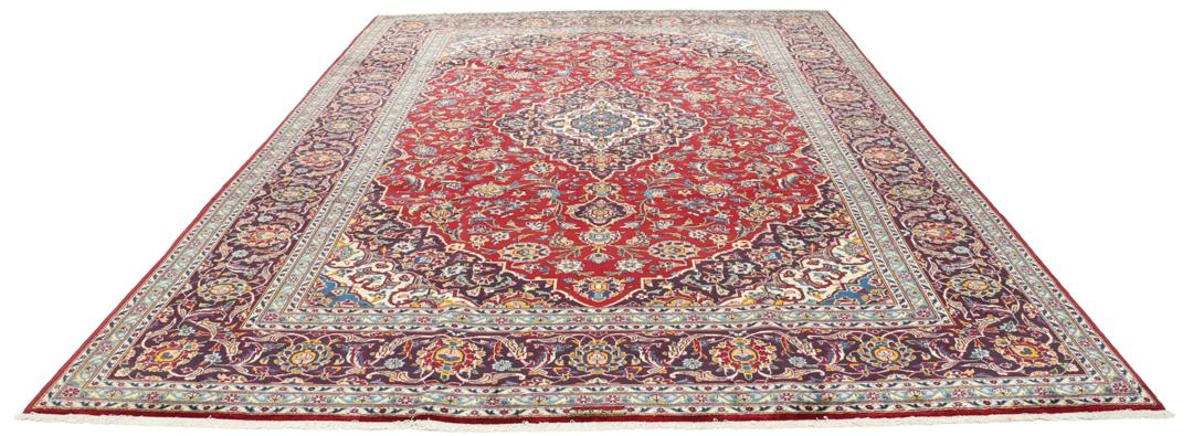 A beautiful red Keshan rug with a central medallion and intricate floral patterns.