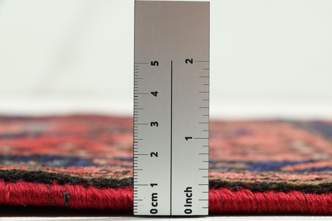 A hand-knotted Hamadan rug from the Middle East featuring a dark-blue and red geometric pattern.