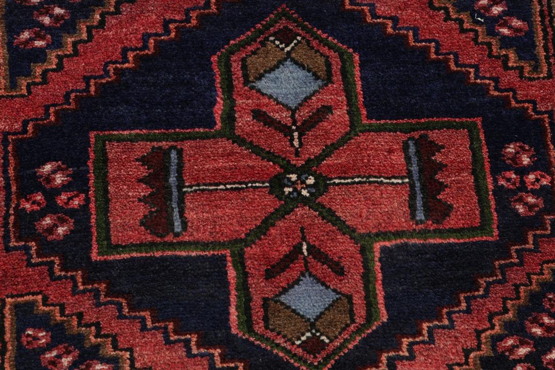 A hand-knotted Hamadan rug from the Middle East featuring a dark-blue and red geometric pattern.