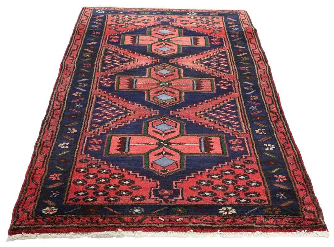 A hand-knotted Hamadan rug from the Middle East featuring a dark-blue and red geometric pattern.