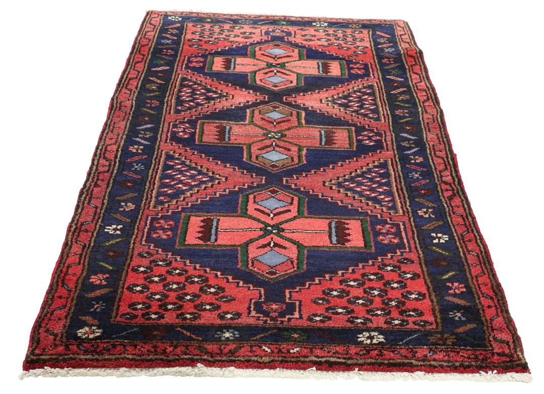 A hand-knotted Hamadan rug from the Middle East featuring a dark-blue and red geometric pattern.
