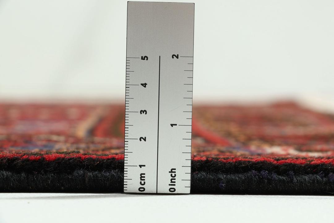 Een handgeknoopt Joshaghan-tapijt uit het Midden-Oosten met een rood en blauw geometrisch medaillonpatroon.