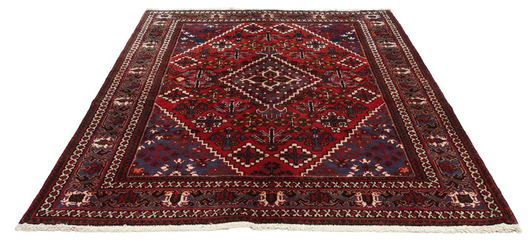Een handgeknoopt Joshaghan-tapijt uit het Midden-Oosten met een rood en blauw geometrisch medaillonpatroon.