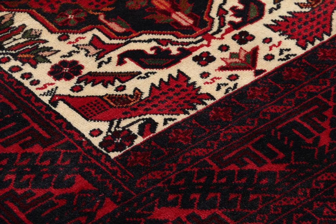 Handgeknoopt Beluch-tapijt in rood en blauw met traditionele tribale patronen
