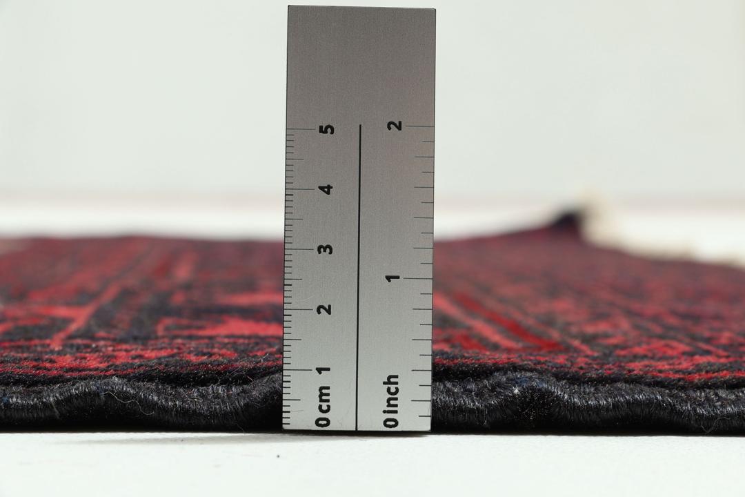 Handgeknoopt Beluch-tapijt in rood en blauw met traditionele tribale patronen