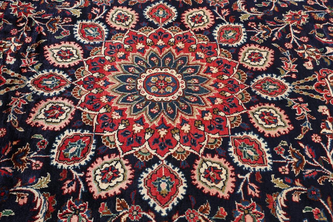 Un tapis Mehraban noué à la main avec un champ bleu foncé et un motif de médaillon floral du Moyen-Orient.