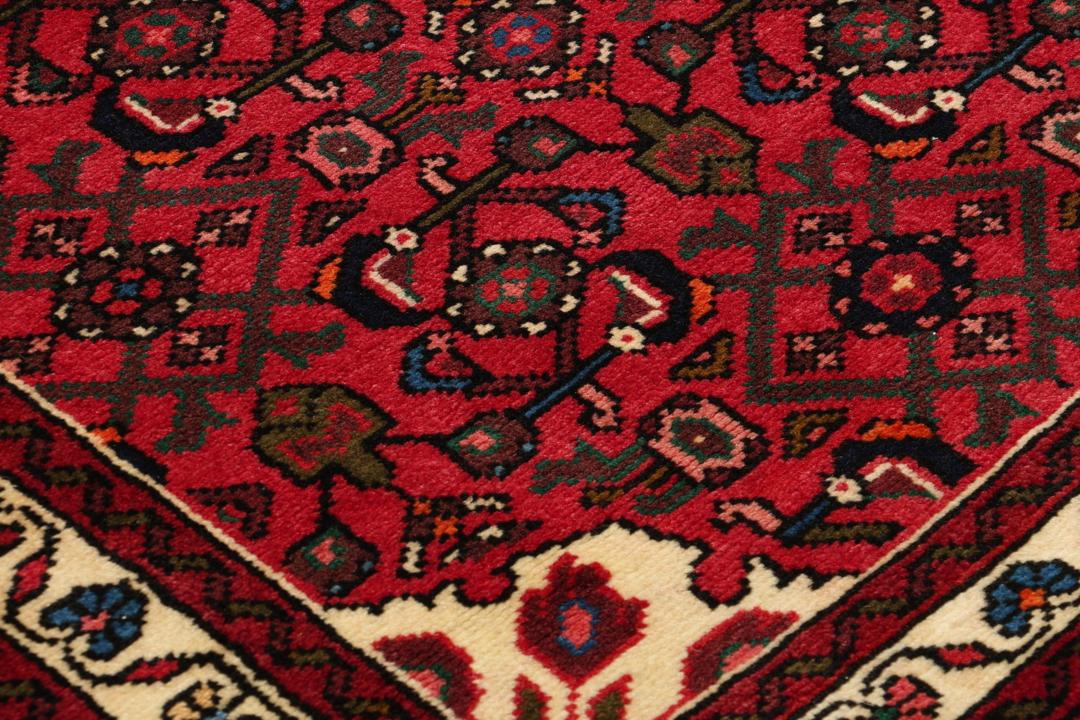 Handgeknoopte Hosseinabad loper in rood met geometrische tribale motieven