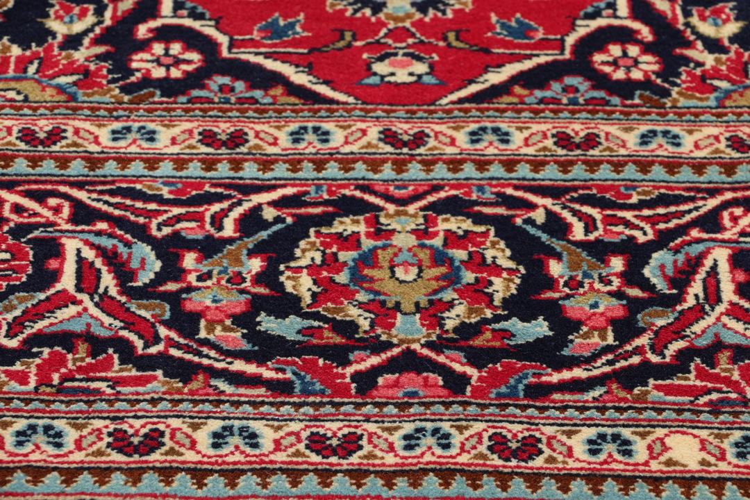 Handgeknoopt Keshan-tapijt uit het Midden-Oosten met een rood veld en blauw medaillon