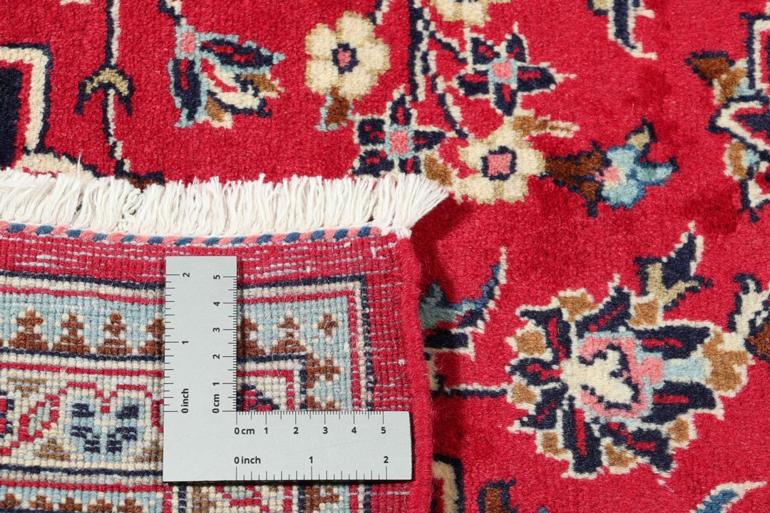 Handgeknoopt Keshan-tapijt uit het Midden-Oosten met een rood veld en blauw medaillon