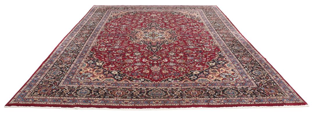 A hand-knotted Mashad rug from the Middle East with a deep red field and intricate floral medallion.