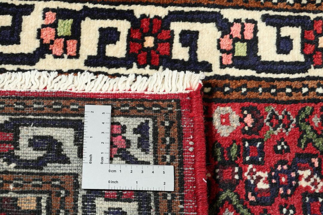 A long, hand-knotted Hosseinabad runner with a red field and traditional geometric motifs.