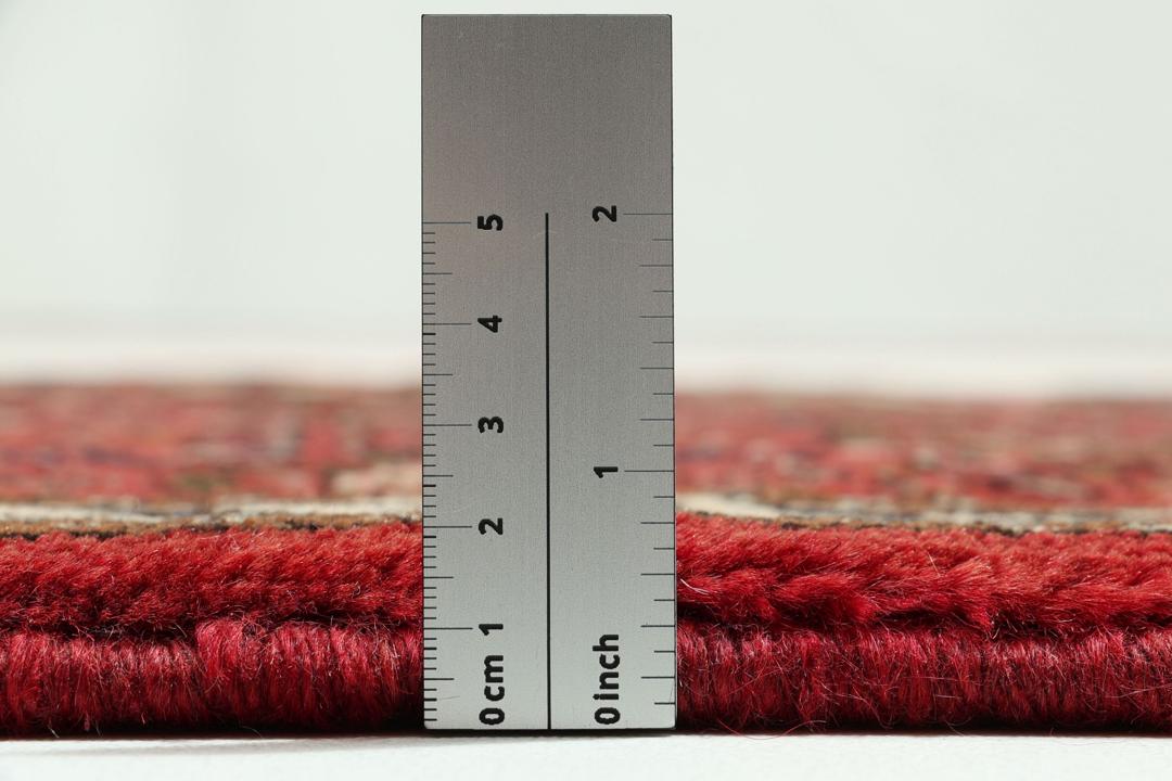 A long, hand-knotted Hosseinabad runner with a red field and traditional geometric motifs.