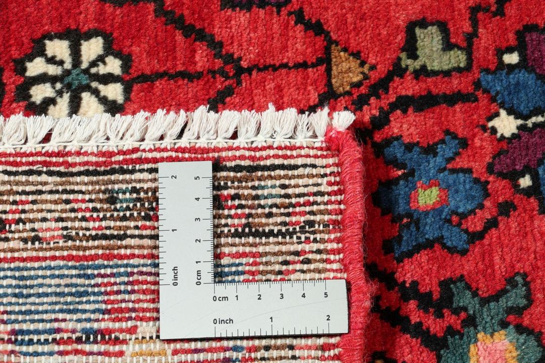 Een handgeknoopt Hamadan-tapijt uit het Midden-Oosten met een rood en blauw medaillonontwerp.