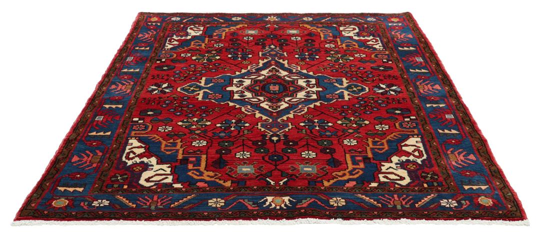 Een handgeknoopt Hamadan-tapijt uit het Midden-Oosten met een rood en blauw medaillonontwerp.