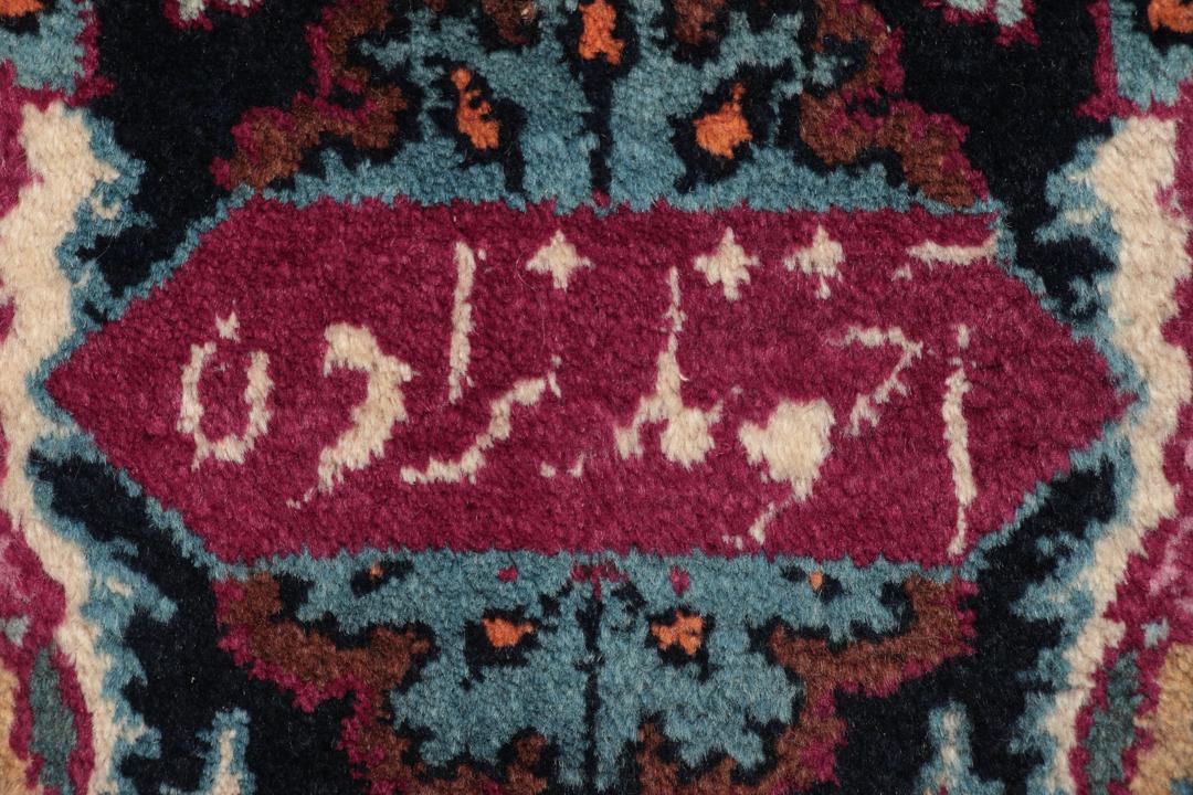 Hand-knotted Mashad rug from the Middle East featuring a dark-red field and floral patterns