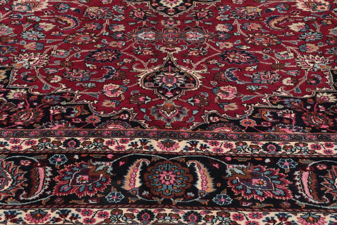 Hand-knotted Mashad rug from the Middle East featuring a dark-red field and floral patterns