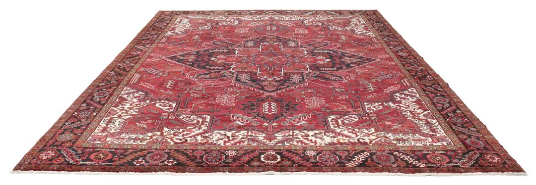 A hand-knotted Heriz rug from the Middle East in deep red and dark tones.
