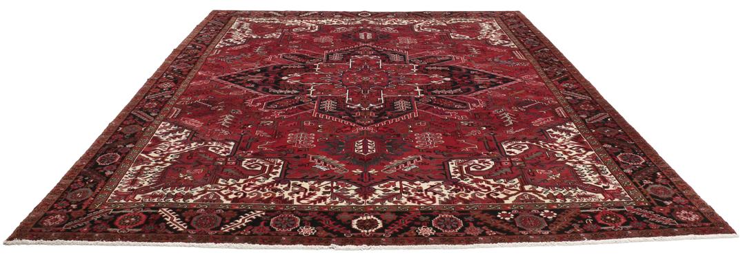 A hand-knotted Heriz rug from the Middle East in deep red and dark tones.