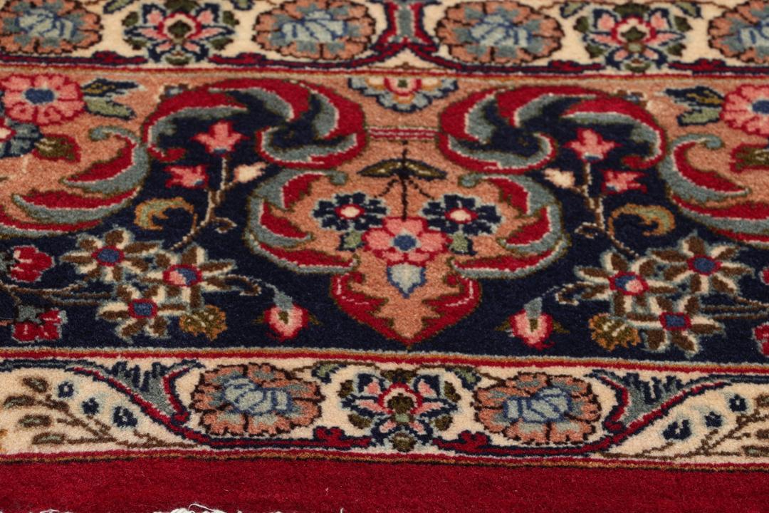 Handgeknüpfter Mashad-Teppich aus dem Mittleren Osten mit rotem Grund und Blumenmustern.
