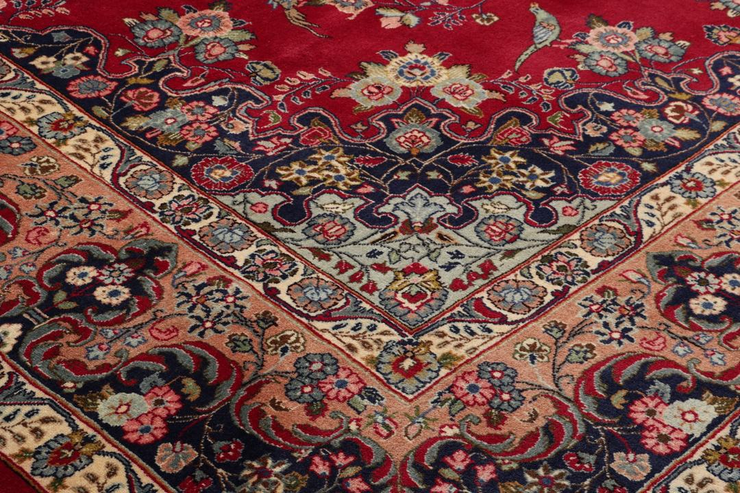 Handgeknüpfter Mashad-Teppich aus dem Mittleren Osten mit rotem Grund und Blumenmustern.