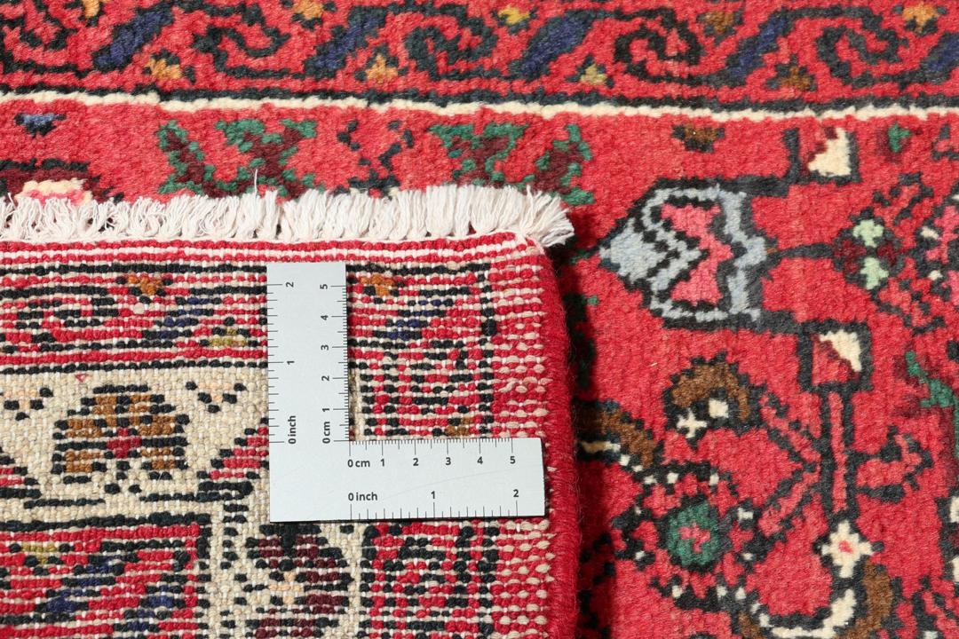 Hand-knotted Hosseinabad runner rug with a vibrant red field, originating from the Middle East.