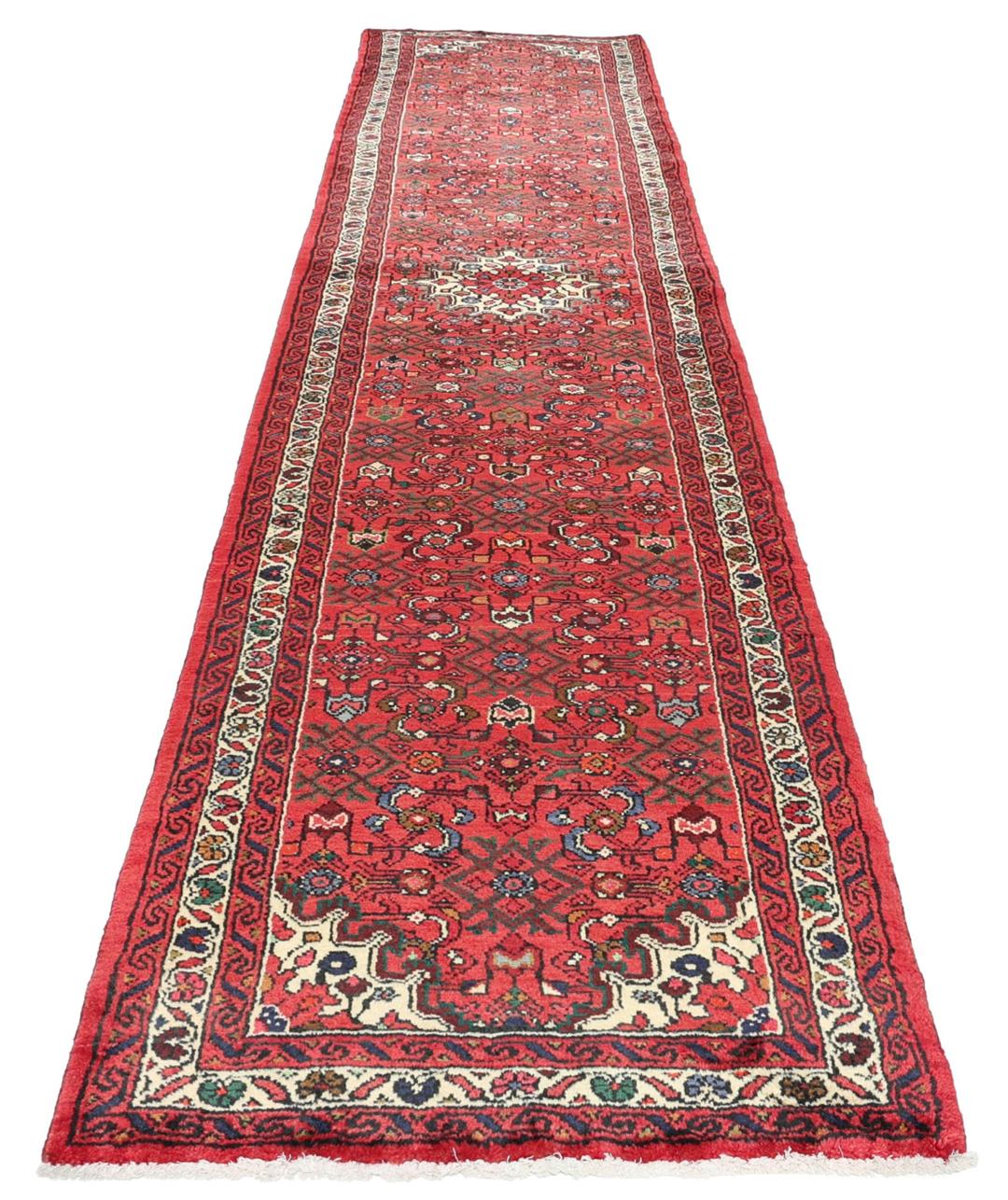 Hand-knotted Hosseinabad runner rug with a vibrant red field, originating from the Middle East.