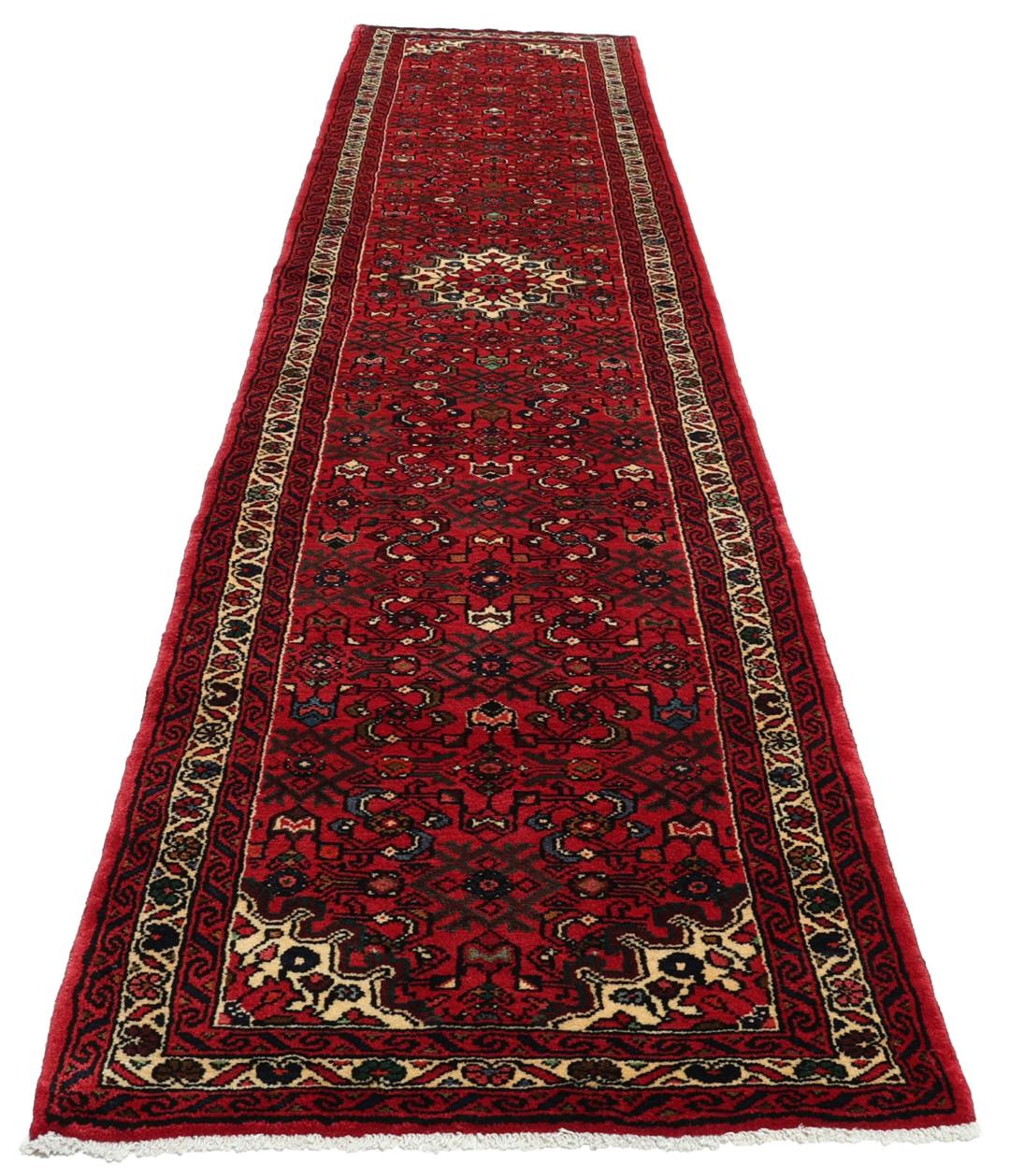 Hand-knotted Hosseinabad runner rug with a vibrant red field, originating from the Middle East.