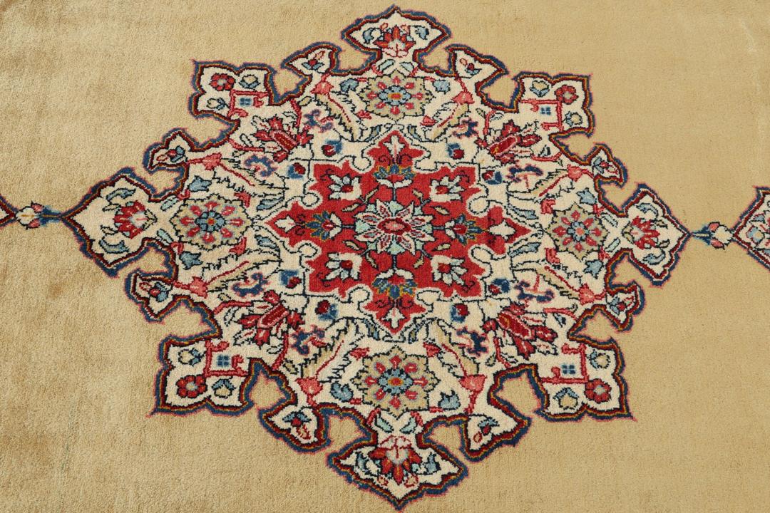 A hand-knotted Sarough rug from the Middle East with a beige field and red accents.