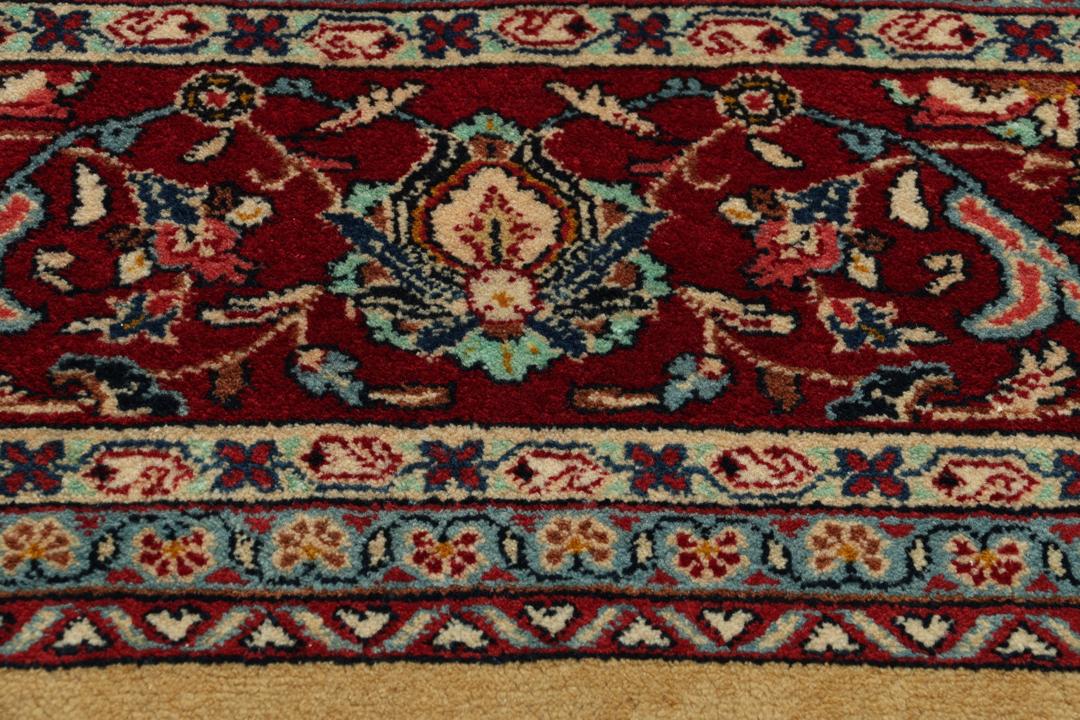 A hand-knotted Sarough rug from the Middle East with a beige field and red accents.