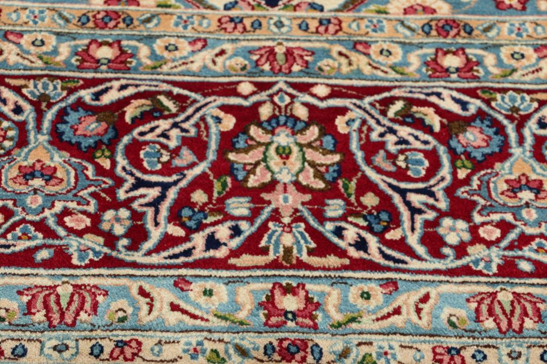 Hand-knotted Kerman rug with a blue and red floral medallion design from the Middle East.