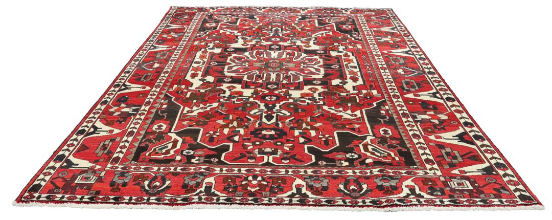 A hand-knotted Middle Eastern Bakhtiari rug featuring a bold red and black floral medallion design.