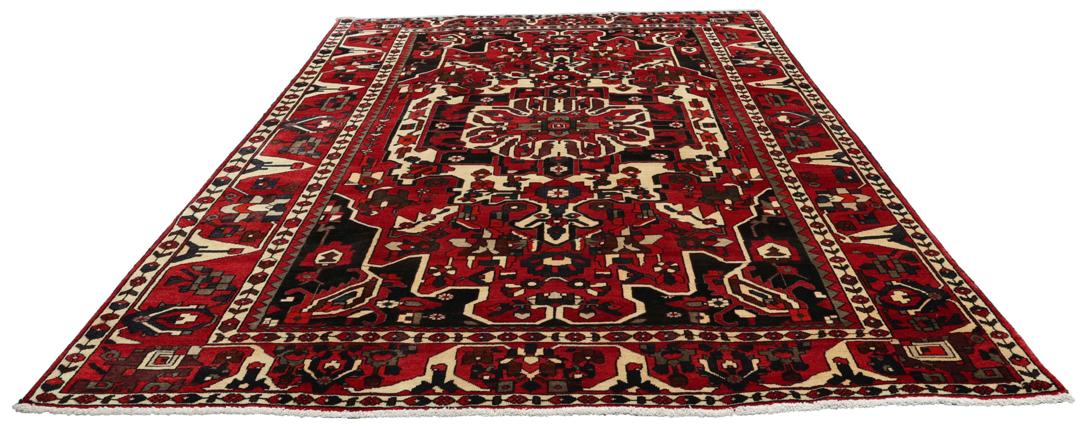 A hand-knotted Middle Eastern Bakhtiari rug featuring a bold red and black floral medallion design.