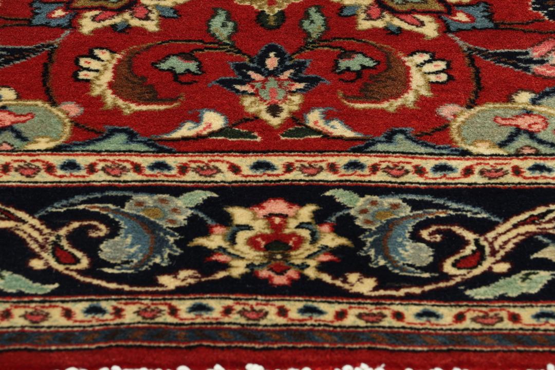 Hand-knotted Sarough rug from the Middle East with a red field and floral patterns.