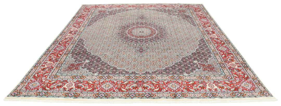 A large rectangular Moud rug from the Middle East featuring a central medallion and ornate floral patterns in multicolor wool.