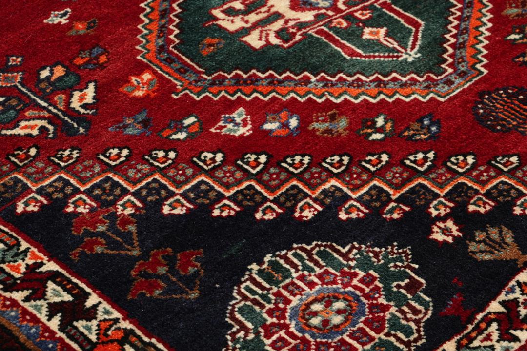 Handgeknoopt Shiraz-tapijt uit het Midden-Oosten met een levendig rood en blauw geometrisch ontwerp.