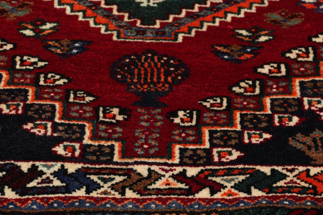 Handgeknoopt Shiraz-tapijt uit het Midden-Oosten met een levendig rood en blauw geometrisch ontwerp.