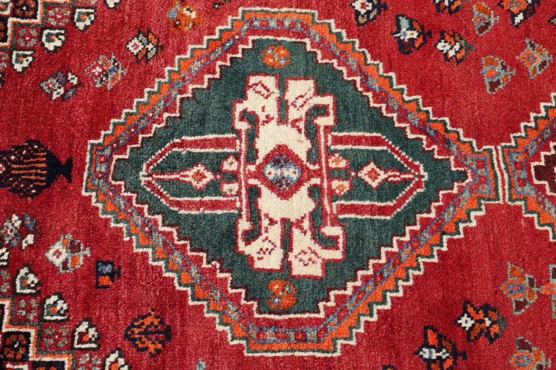 Handgeknoopt Shiraz-tapijt uit het Midden-Oosten met een levendig rood en blauw geometrisch ontwerp.