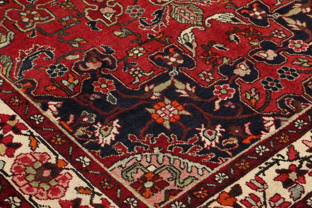 Hand-knotted Tafresch Wool rug from the Middle East featuring a red and blue floral design