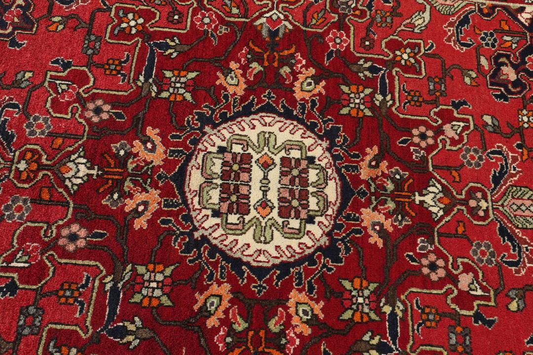 Hand-knotted Tafresch Wool rug from the Middle East featuring a red and blue floral design