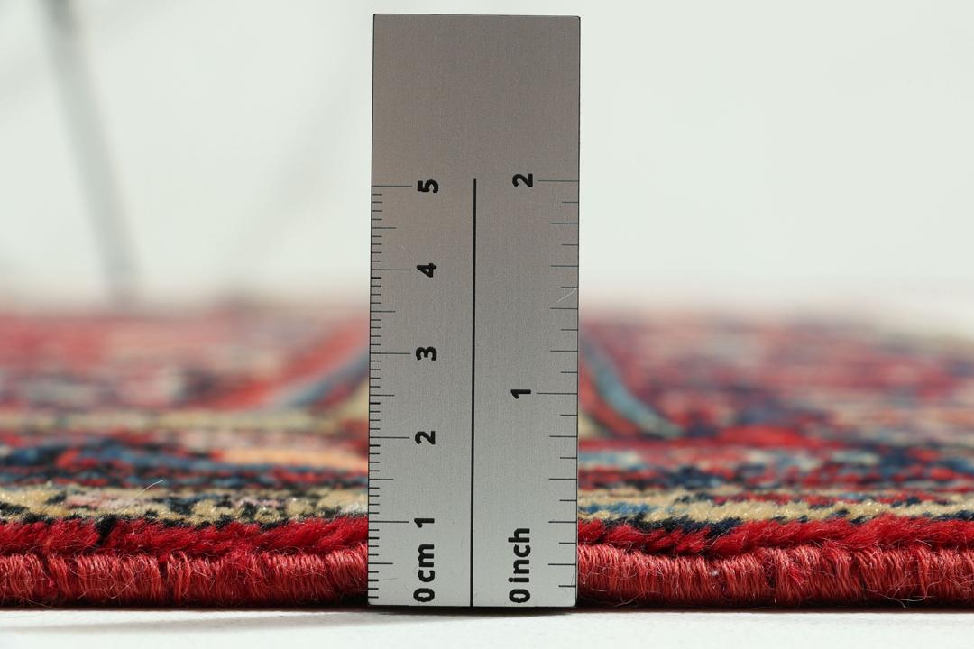 Handgeknüpfter Teppich aus dem Nahen Osten mit einem satten roten Grund und filigranen floralen Mustern.