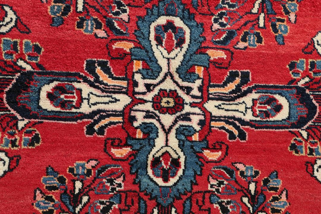 Handgeknüpfter Teppich aus dem Nahen Osten mit einem satten roten Grund und filigranen floralen Mustern.