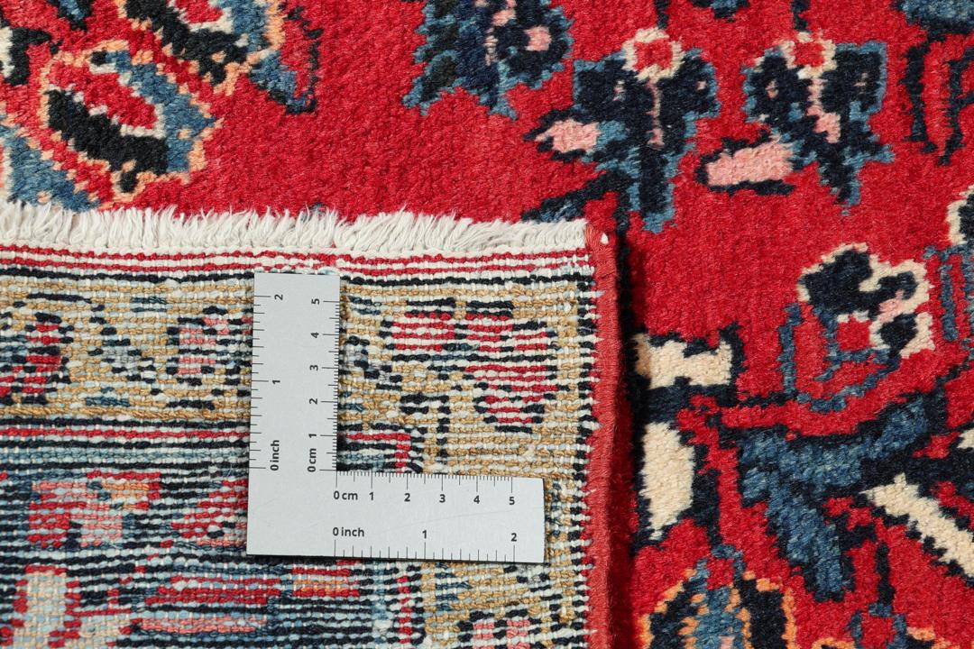 Handgeknüpfter Teppich aus dem Nahen Osten mit einem satten roten Grund und filigranen floralen Mustern.