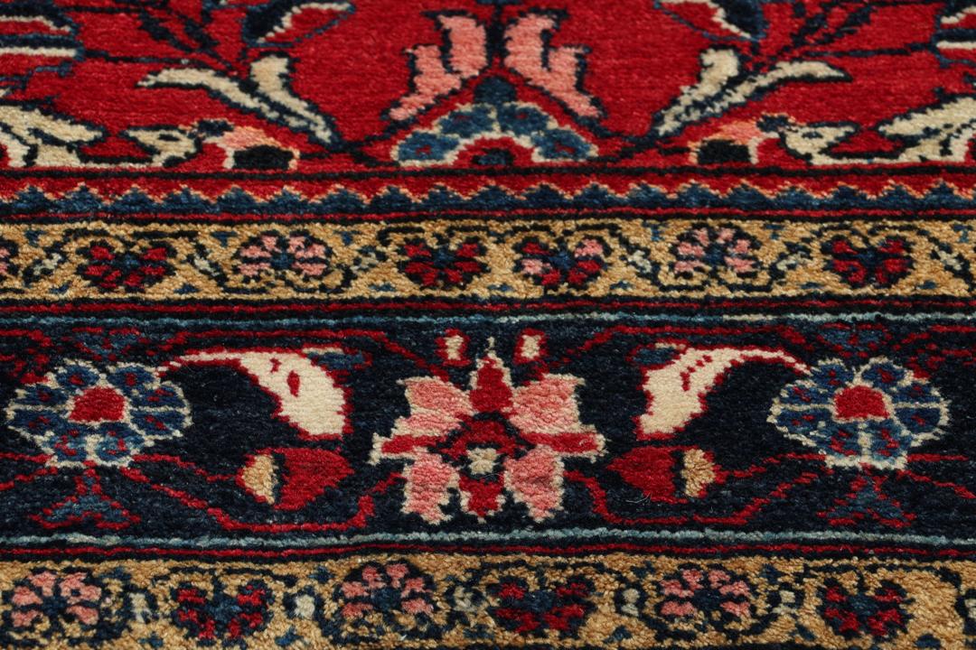 Handgeknüpfter Teppich aus dem Nahen Osten mit einem satten roten Grund und filigranen floralen Mustern.